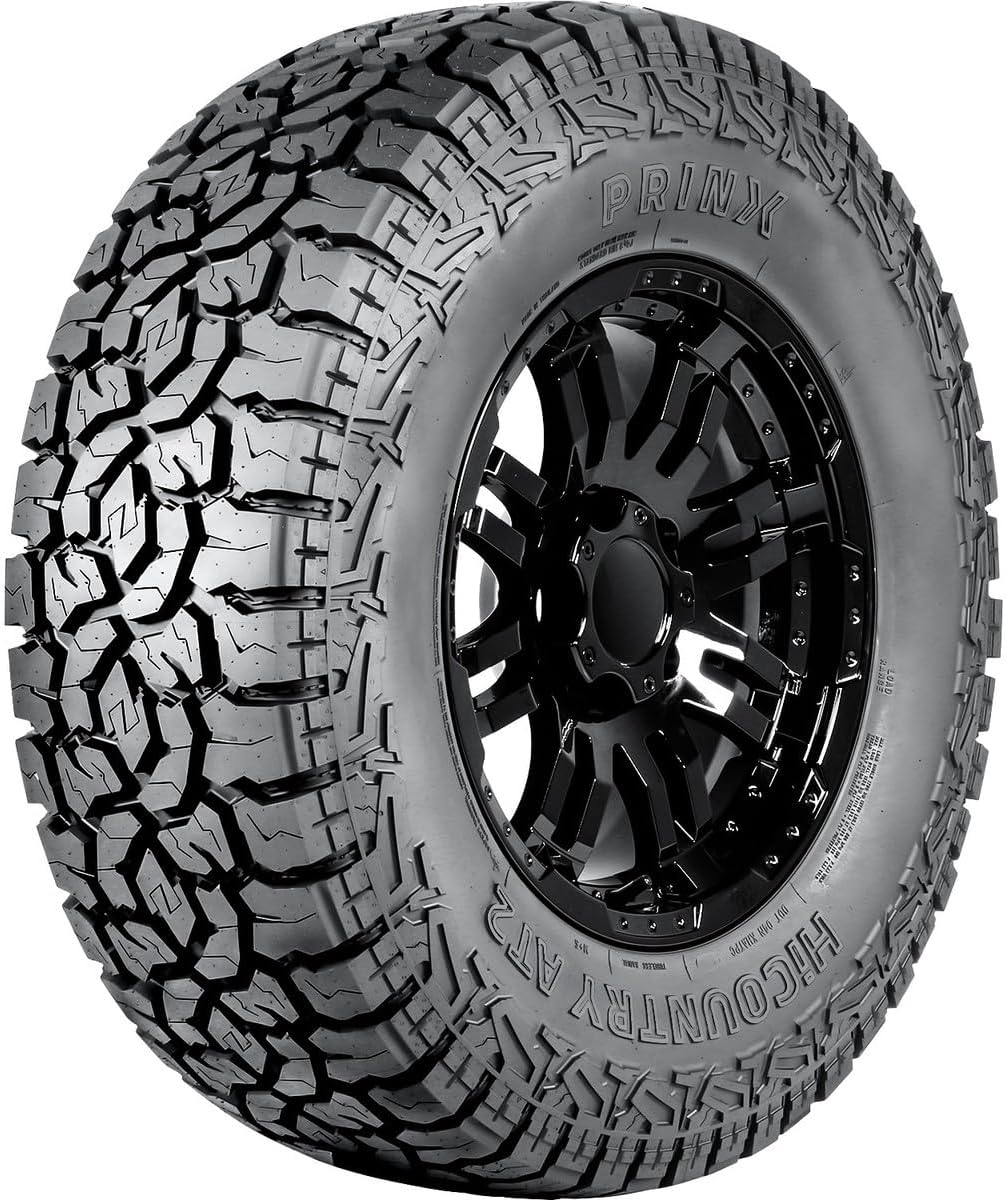 All-terrain light truck tire on a black alloy wheel, an aggressive shoulder tread pattern in a Ford F-150 fitment